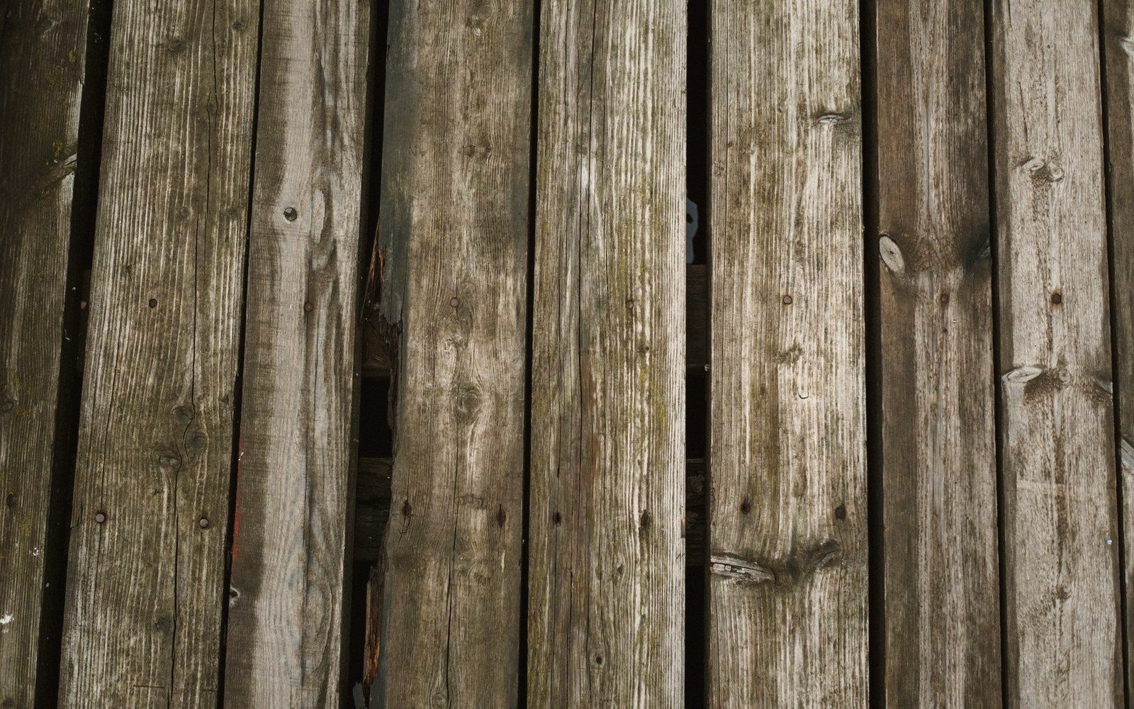 Weathered transverse deck planking inside a covered bridge