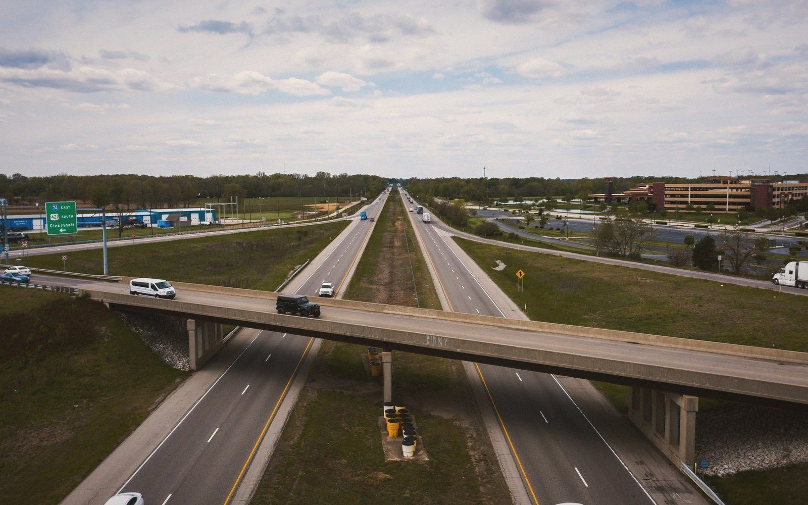 Aerial view of an overpass crossing a multilane highway near office buildings